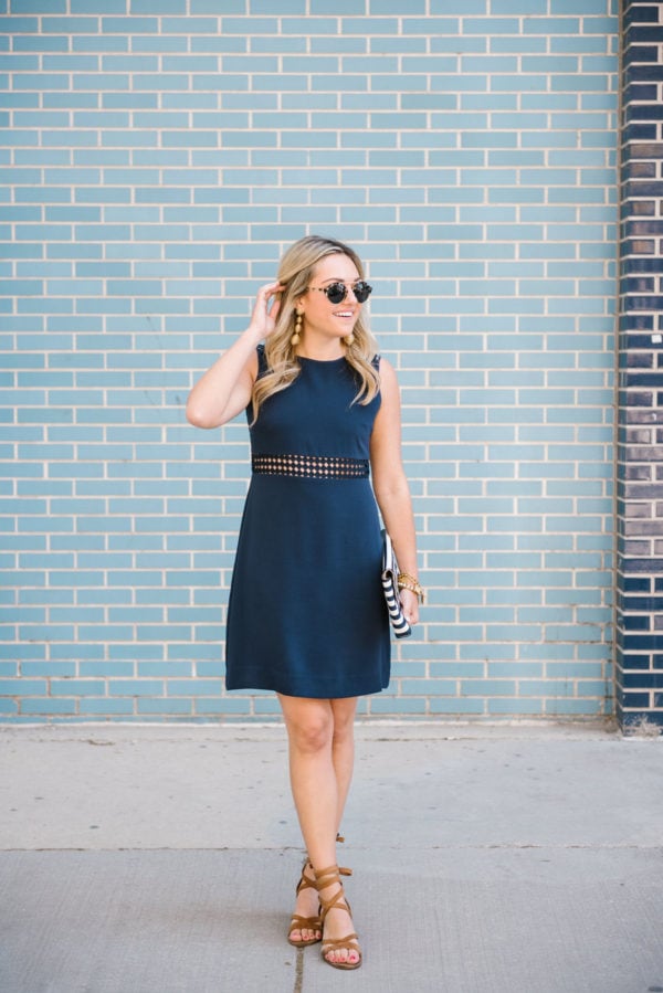 Jessica of Bows & Sequins, a Chicago-based fashion blog, wearing a navy Sail to Sable sleeveless dress with lace up sandals and Illesteva sunglasses.