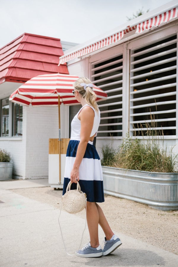 Bows & Sequins wearing a navy striped Elizabeth McKay dress with gingham sneakers and a J.Crew eyelet hair bow.