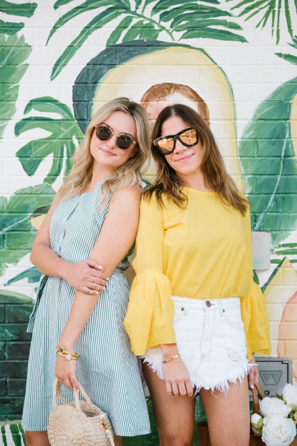 Chicago fashion blogger Bows & Sequins wearing Hadid tortoise sunglasses and a button down dress with a Clare V straw bag, and fitness lifestyle blogger Among Other Things wearing mirrored sunglasses, a bell sleeve top, and One Teaspoon raw hem denim skirt.