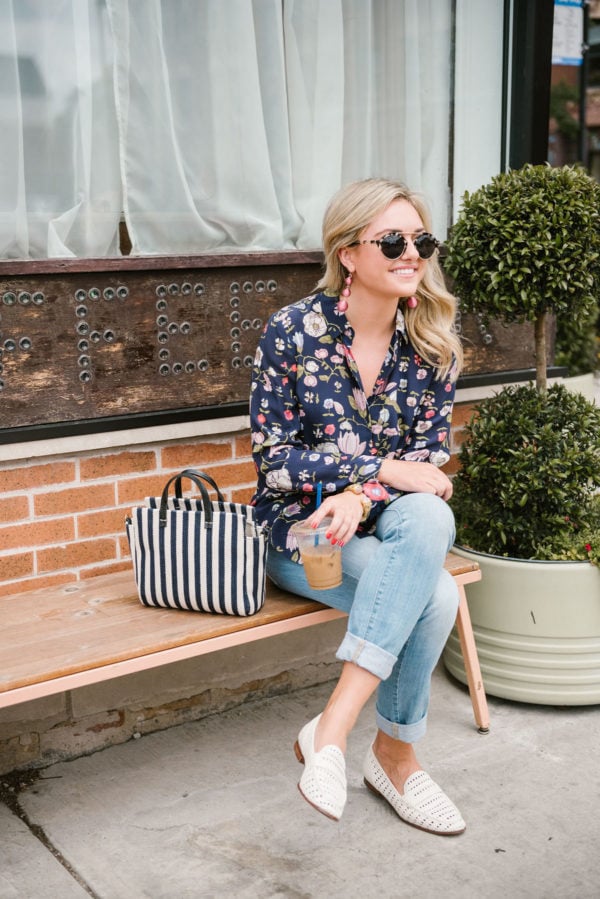 Bows & Sequins wearing a floral blouse with light wash denim and white leather loafers.