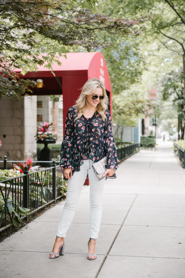 Chicago fashion blogger Bows & Sequins wearing a Moon River floral blouse, Gucci aviators, white corduroy jeans, and Dolce Vita studded heels.