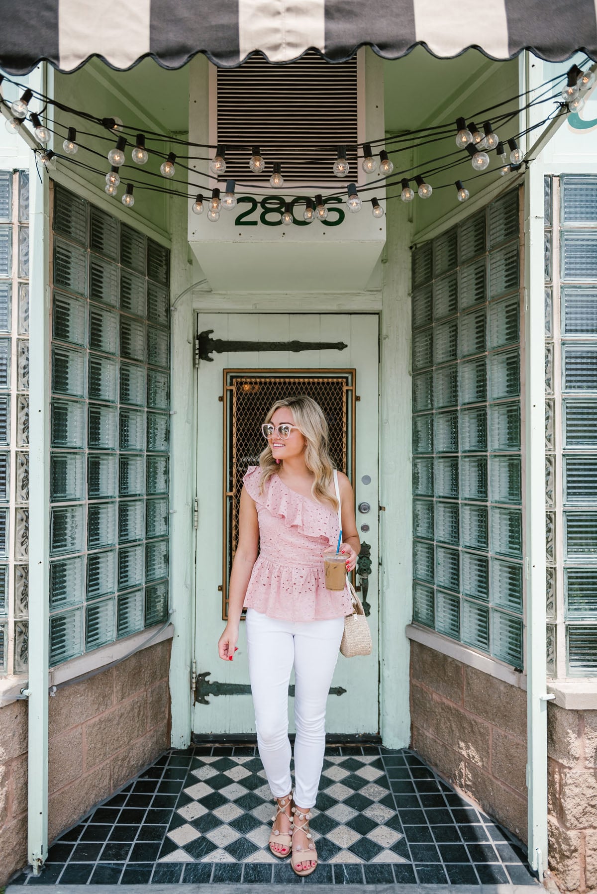 Bows & Sequins wearing a J.O.A. pink peplum top, Old Navy white denim, heeled pom pom sandals, and a Clare V straw crossbody bag.