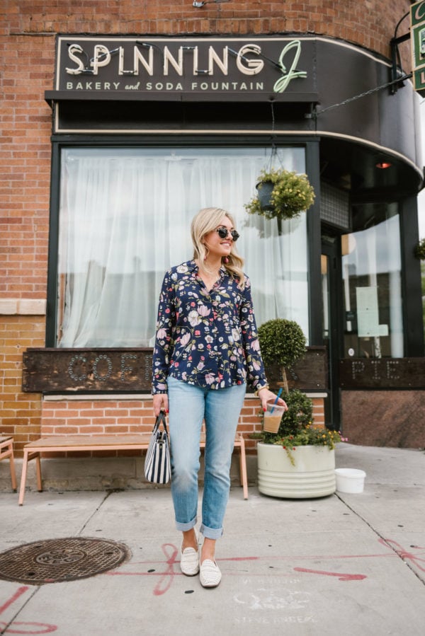 Chicago blogger Bows & Sequins outside the Spinning J coffee bar wearing a floral blouse from Nordstrom Rack, Vineyard Vines straight leg jeans, white leather loafers, and a Julie Vos cuff.