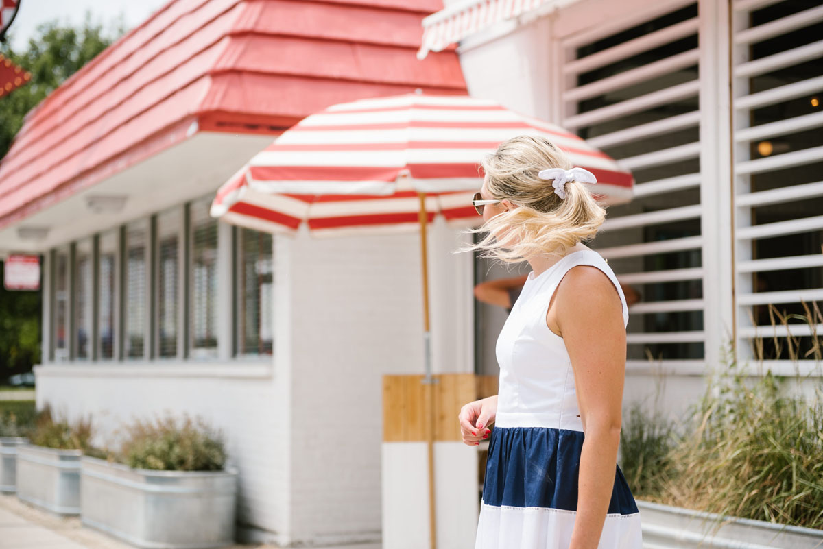 Jessica Sturdy, of the fashion and lifestyle blog Bows & Sequins, wearing a J.Crew white eyelet hair bow and an Elizabeth McKay navy striped dress.