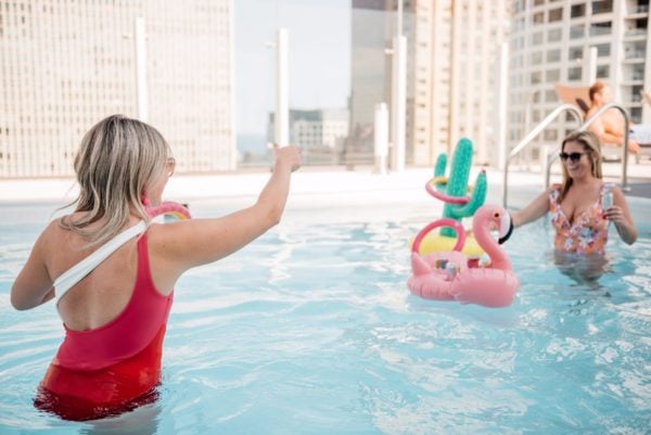 Chicago bloggers having a pool party with flamingo and cactus pool floats.