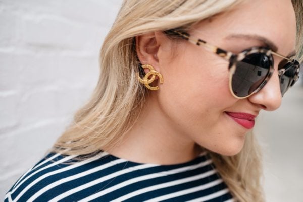 Chicago-based fashion and lifestyle blogger Bows & Sequins wearing gold Chanel earrings, Illesteva sunglasses, and Bare Minerals 'Juicy' matte lipstick.