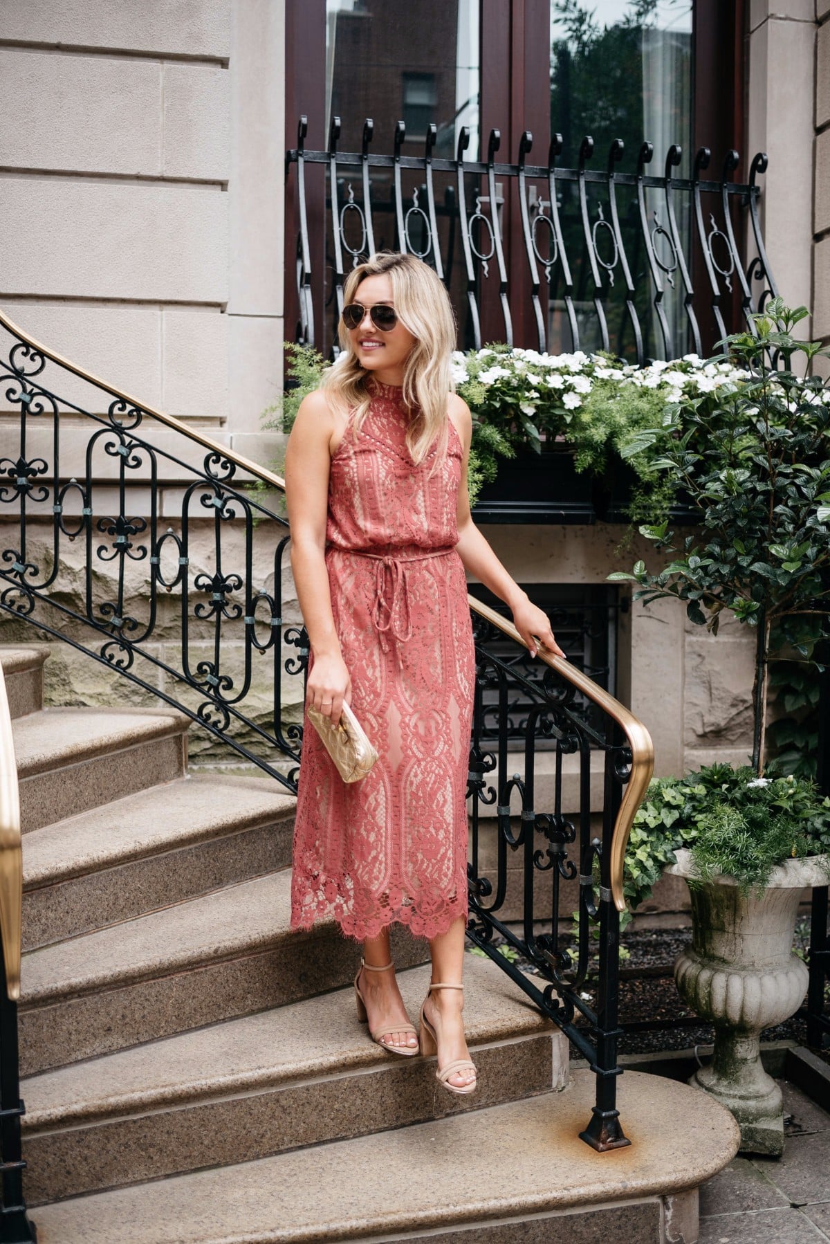 Bows & Sequins wearing Gucci aviators, a pink Wayf dress, and ankle strap heels with a Marc Jacobs metallic bag.
