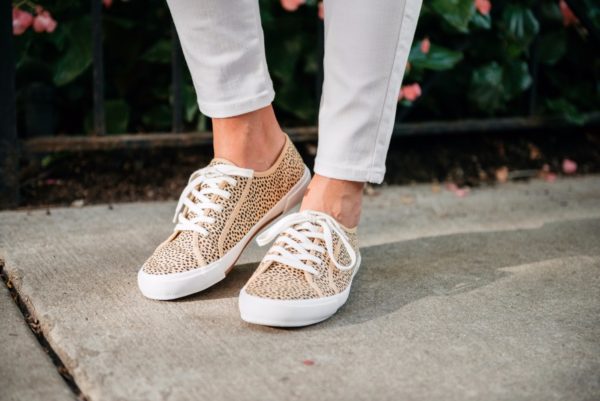 Bows & Sequins wearing Old Navy white denim jeans and leopard sneakers.