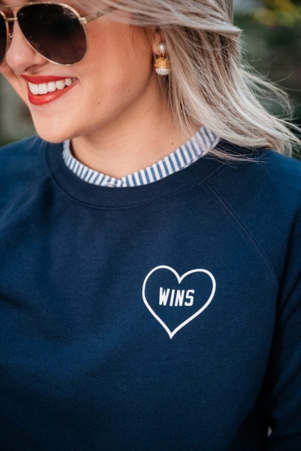 Bows & Sequins wearing Gucci aviators, Julie Vos pearl earrings, and an Old Navy Love Wins graphic sweatshirt.