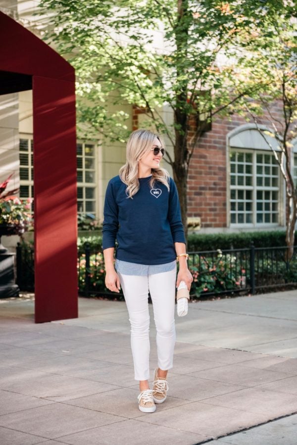 Bows & Sequins wearing an Old Navy Love Wins graphic sweatshirt, white jeans, leopard print sneakers, and a Julie Vos gold cuff with a Vineyard Vines wicker clutch.