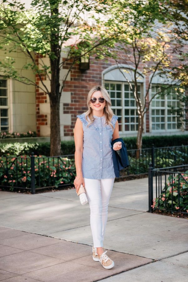Fashion and lifestyle blogger Bows & Sequins wearing a sleeveless chambray ruffle top and Old Navy white denim with leopard print sneakers and a Vineyard Vines wicker clutch.