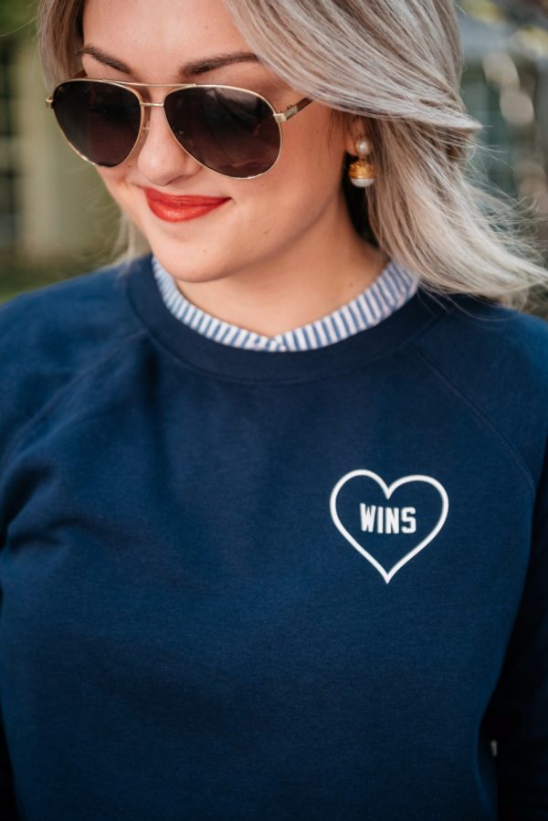 Bows & Sequins wearing Gucci aviators, Julie Vos pearl earrings, and an Old Navy Love Wins graphic sweatshirt.