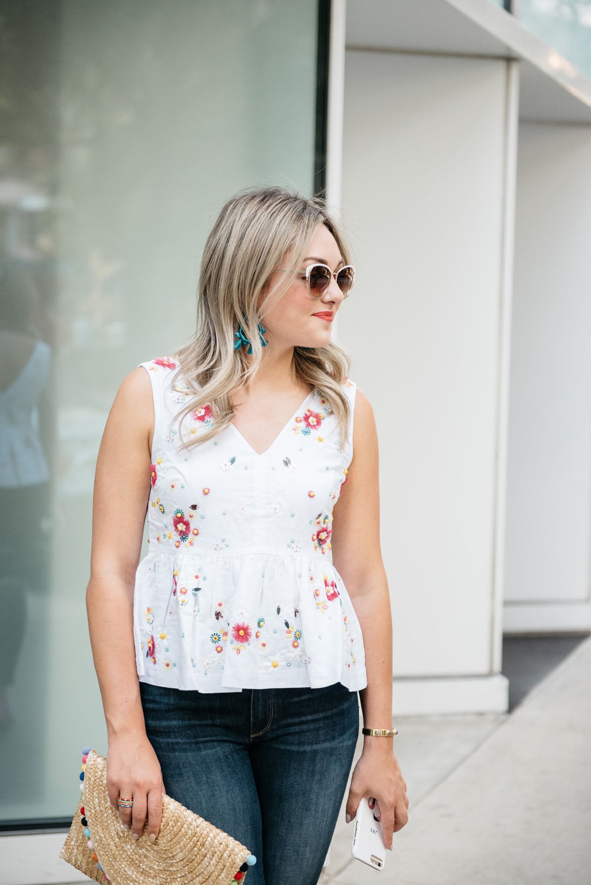 Bows & Sequins wearing Call It Spring white sunglasses, BaubleBar Sardina earrings, and a J.Crew embroidered peplum top.