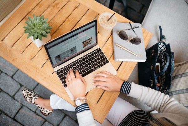 Bows & Sequins working on a Macbook at Petit Margeaux at the Waldorf Astoria in Chicago with a Gigi New York monogrammed leather notebook.