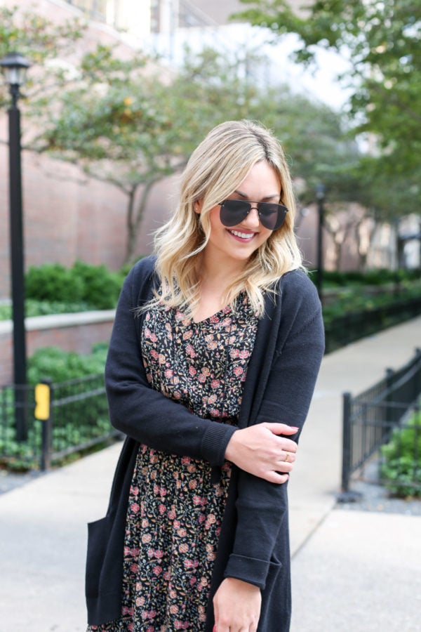 Bows & Sequins wearing matte aviator sunglasses, a black cardigan, and a floral midi dress from Old Navy for fall.