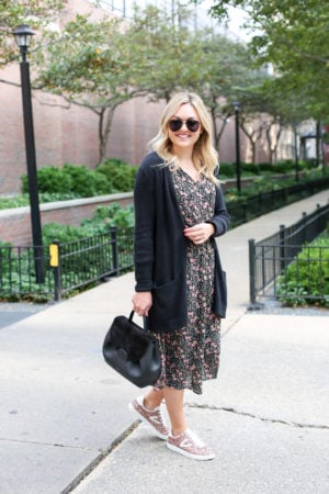 Chicago fashion blogger Bows & Sequins wearing a black cardigan, fall floral midi dress, and glitter sneaker with a black leather handbag.