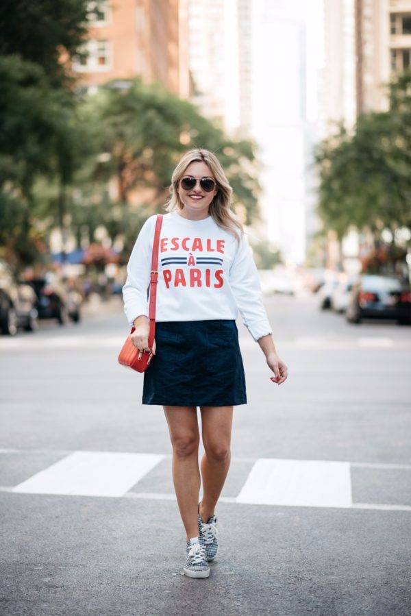 Chicago-based blogger Bows & Sequins wearing Gucci aviators, a French Disorder Paris sweatshirt, and an Old Navy blue suede skirt and Claudie Pierlot gingham sneakers with a Talbots red leather bag.