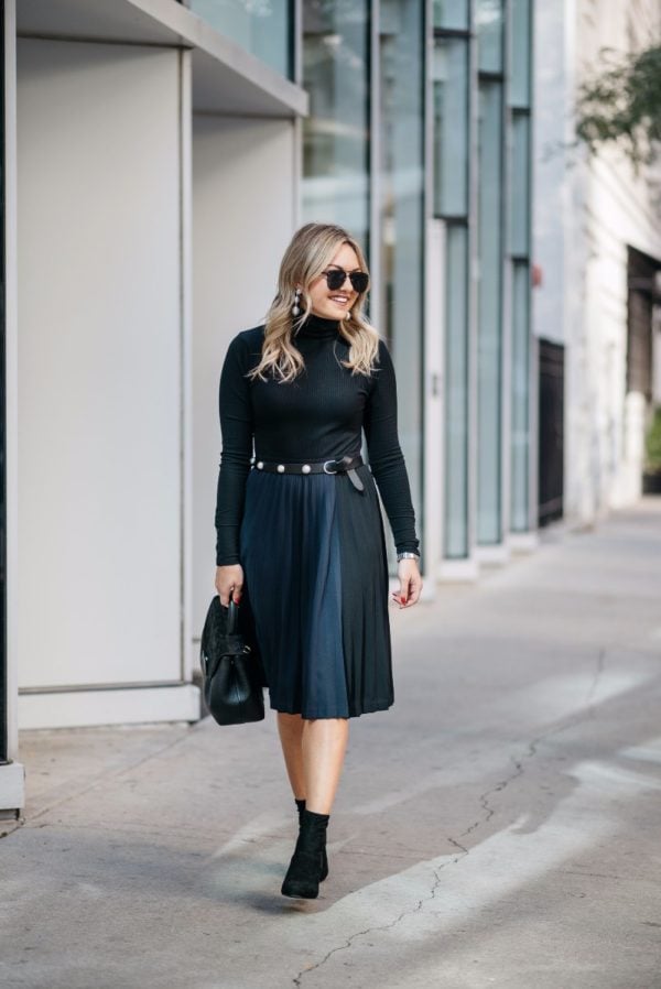 Bows & Sequins wearing Baublebar silver ball earrings, a J.Crew turtleneck, navy and black pleated skirt, lucite ankle boots, and a pearl studded belt with a Polene top-handle bag.