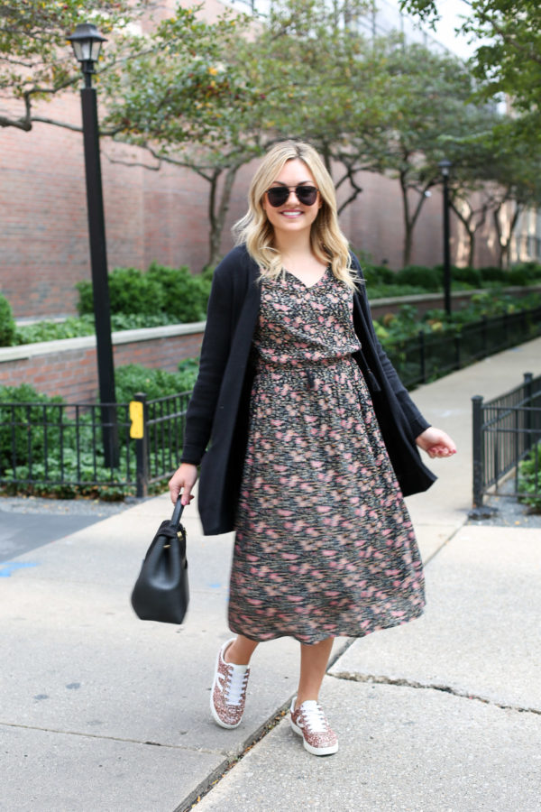 Bows & Sequiins wearing a black Old Navy cardigan, a midi floral dress, and Tretorn pink glitter sneakers with a top-handle black leather handbag.