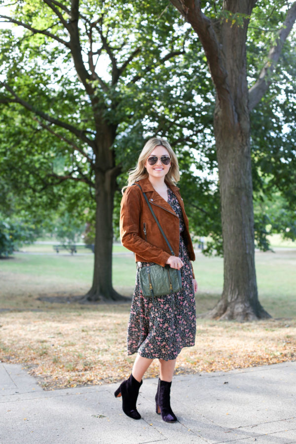 Jessica from Bows & Sequins wearing a Blank NYC cognac suede jacket, an Old Navy floral midi dress, a Joelle Hawkens green leather shoulder bag, Marc Fisher purple velvet booties and aviators.
