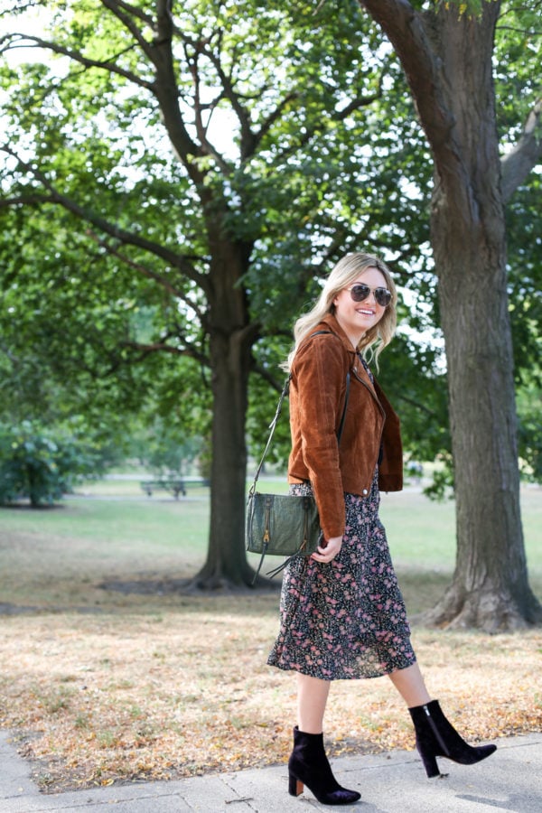 Chicago lifestyle blogger Bows & Sequins wearing a Blank NYC cognac suede jacket, an Old Navy floral midi dress, a Joelle Hawkens green leather shoulder bag, Marc Fisher purple velvet booties and aviators.