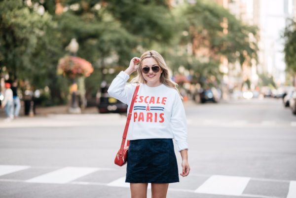 Bows & Sequins wearing a French Disorder Parisian-inspired sweatshirt with a red leather bag from Talbots and a navy suede skirt.