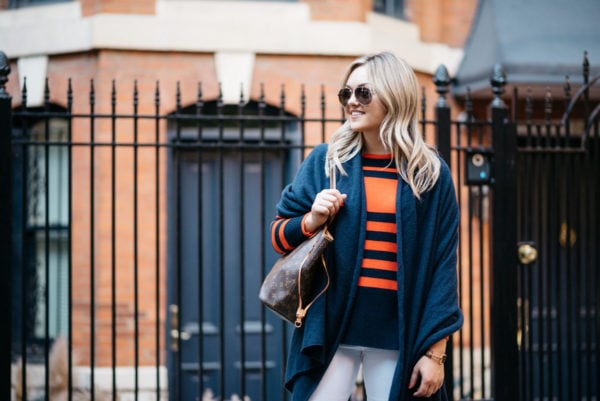 Bows & Sequins wearing Gucci aviators, an orange and blue striped sweater and a navy blue cashmere wrap with a Louis Vuitton Neverfull tote.