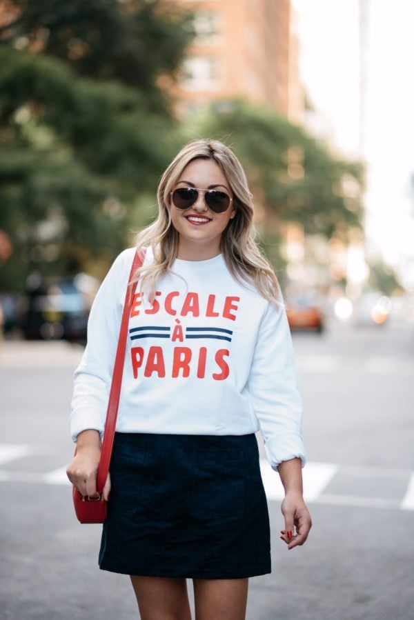 Bows & Sequins wearing Gucci aviators, a French Disorder Paris sweatshirt, and an Old Navy blue suede skirt with a Talbots red leather bag.