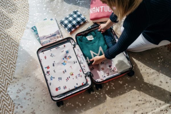 Travel and lifestyle blogger Bows & Sequins using a pink hard shell Away x Gray Malin suitcase.
