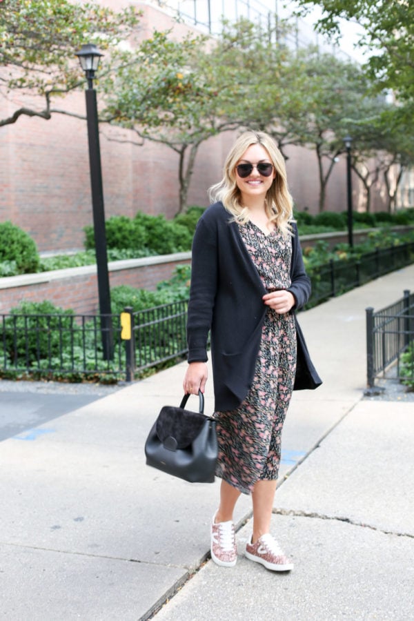 Bows & Sequins wearing matte aviators, a black cardigan, floral Old Navy midi dress, and Tretorn pink sneakers with a Polene top-handle leather bag.