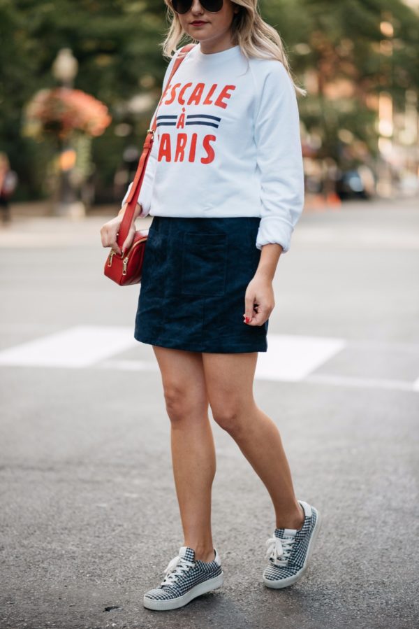 Bows & Sequins wearing Gucci aviators, a French Disorder sweatshirt, an Old Navy blue suede skirt, and Claudie Pierlot gingham sneakers with a Talbots red leather bag.