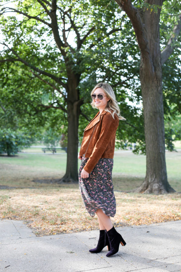 Jessica from Bows & Sequins wearing a Blank NYC cognac suede jacket, an Old Navy floral midi dress, a Joelle Hawkens green leather shoulder bag, Marc Fisher purple velvet booties and aviators.