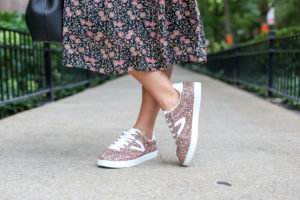 Bows & Sequins wearing a floral dress and Tretorn pink glitter sneakers.