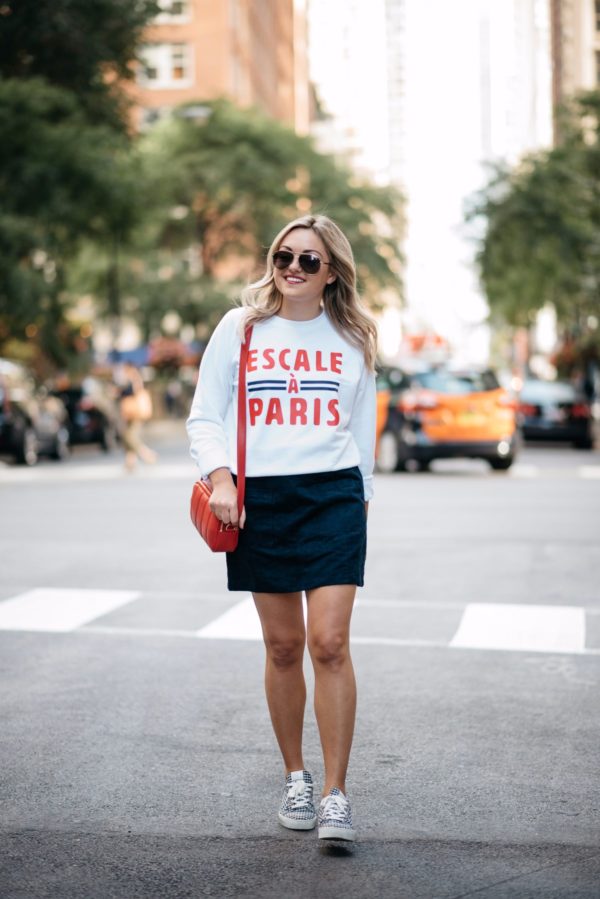 Bows & Sequins wearing a Paris-inspired sweatshirt with an Old Navy suede skirt and Claudie Pierlot navy gingham sneakers.