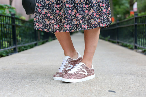 Bows & Sequins wearing a floral dress and Tretorn pink glitter sneakers.