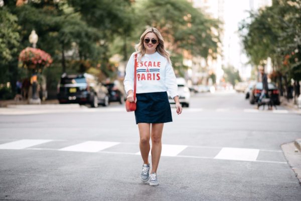 Bows & Sequins wearing a Paris-inspired sweatshirt with an Old Navy suede skirt and Claudie Pierlot navy gingham sneakers.