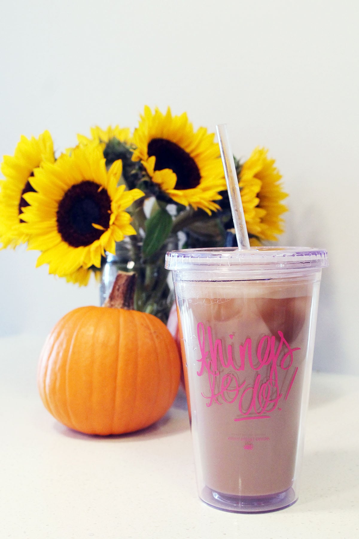 Ashley Brooke Designs Things to Do Clear Tumbler Travel Mug with a pumpkin and sunflowers fall decor.