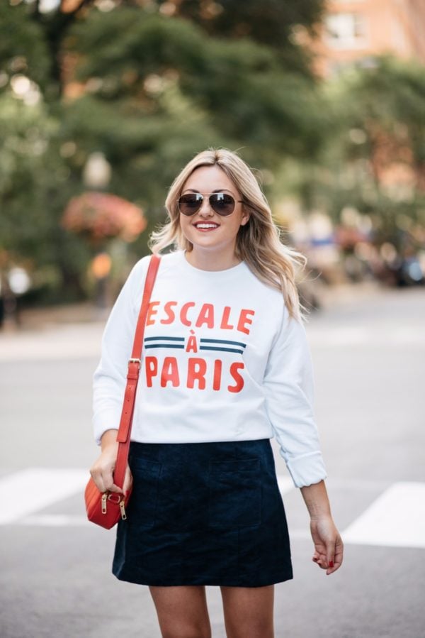 Bows & Sequins wearing Gucci aviators, a French Disorder Paris sweatshirt, and an Old Navy blue suede skirt with a Talbots red leather bag.