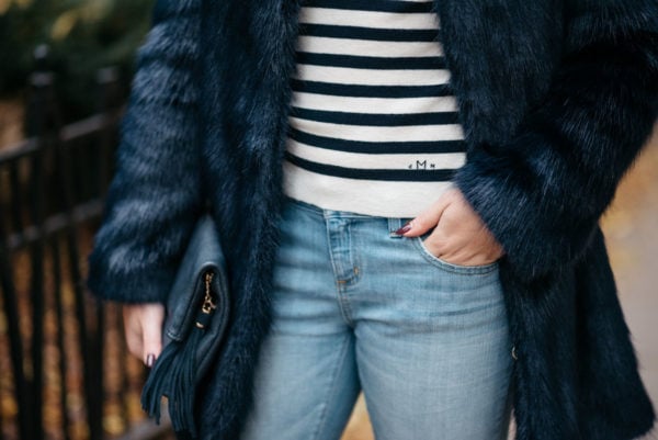Jessica Sturdy wearing a Miranda Dunn London faux fur coat, MDN striped turtleneck and Vineyard Vines boyfriend jeans with an Azalea Blue foldover clutch.