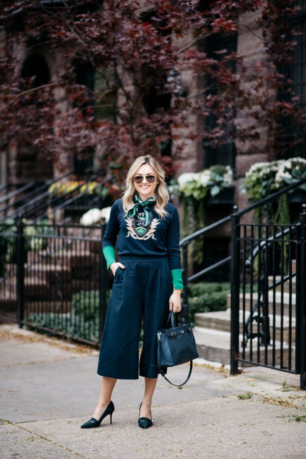 Jessica Rose Sturdy wearing Gucci aviators, a silk neck scarf, MDN green and navy crest sweater, Old Navy blue culotte pants, and J.Crew blackwatch plaid pumps with a Kate Spade navy tote.