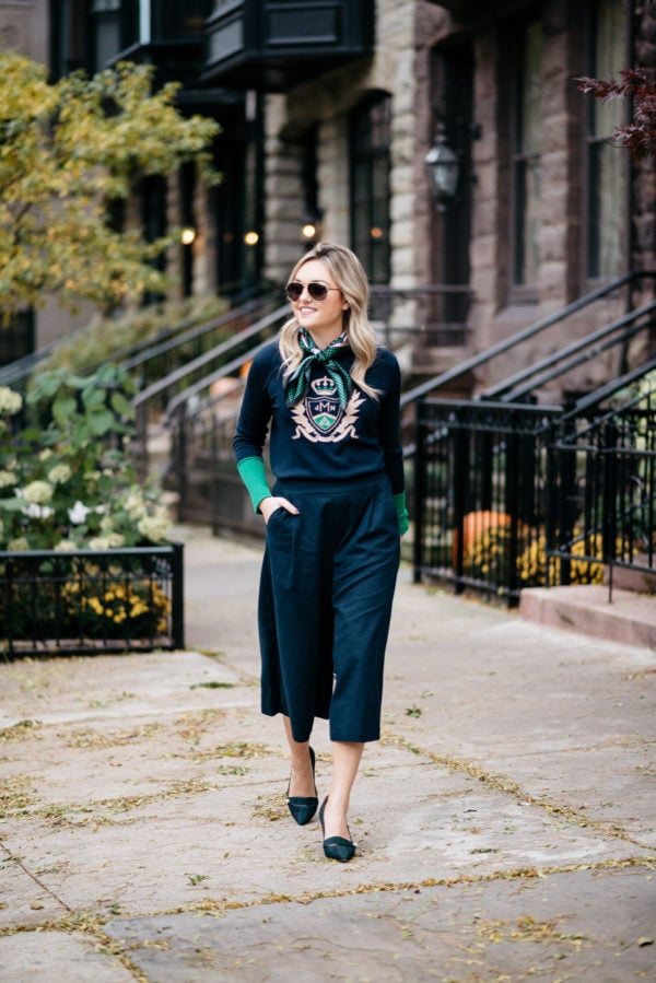 Jessica Sturdy wearing Gucci aviators, a silk neck scarf, MDN crest sweater, Old Navy blue culotte pants, and J.Crew blackwatch plaid pumps with a Kate Spade navy tote.