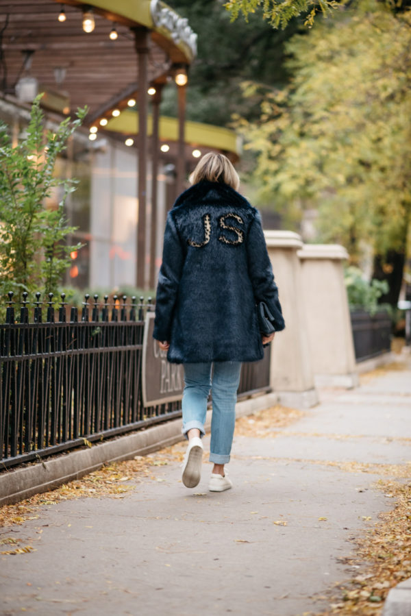 Jessica Rose Sturdy wearing a leopard-print monogrammed faux fur Miranda Dunn coat with Vineyard Vines boyfriend jeans and Sezane Paris Jack leather sneakers.