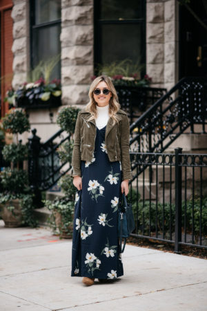 Chicago fashion blogger Jessica Sturdy of Bows & Sequins wearing a floral maxi dress in the fall with a suede moto jacket, cream turtleneck, and suede over the knee booties.
