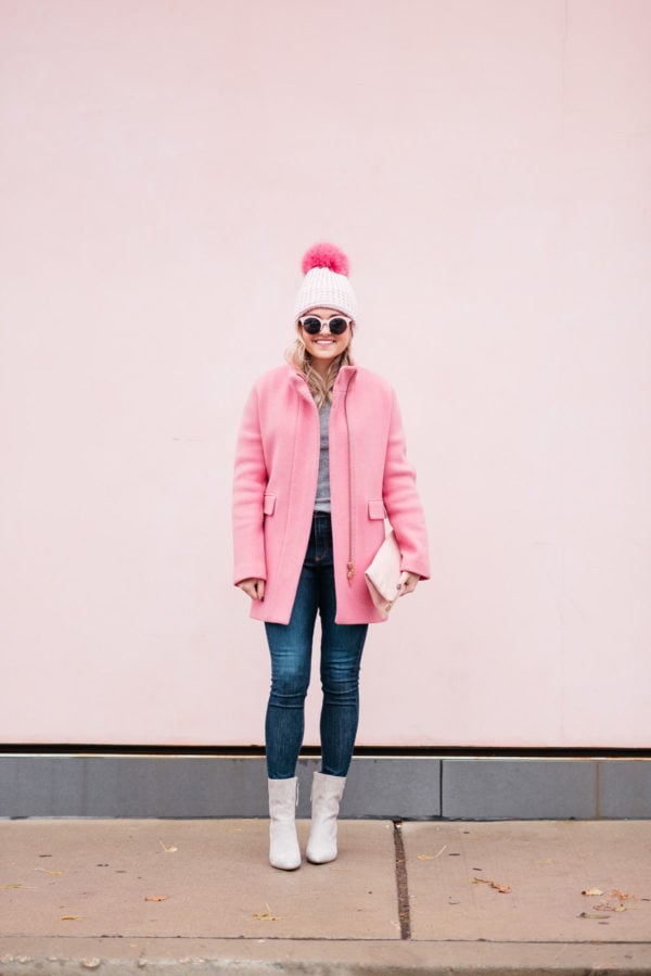 Chicago blogger Jessica Rose Sturdy of Bows & Sequins wearing pink sunglasses, a pink pom pom hat, a J.Crew winter coat, Rag & Bone jeans, and Linea Paolo suede ankle booties via Nordstrom.