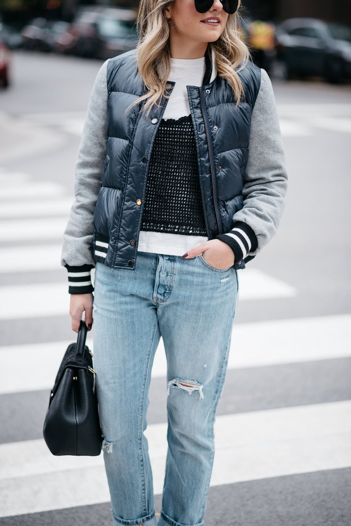 Jessica Sturdy of Bows & Sequins wearing a Veronica Beard bomber jacket, a layered tee and crochet tank, Levi 501 jeans with Steve Madden lucite booties with a Polene Paris top-handle bag.