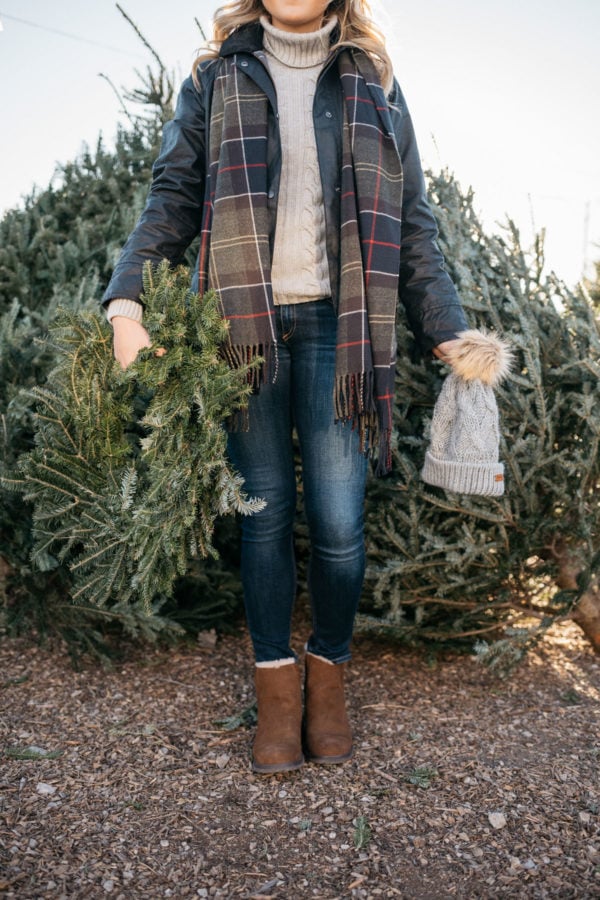 Jessica Sturdy of Bows & Sequins wearing a Barbour tartan scarf, a grey turtleneck, a black Beadnell jacket, Rag & Bone jeans, and Emu Australia shearling ankle booties.