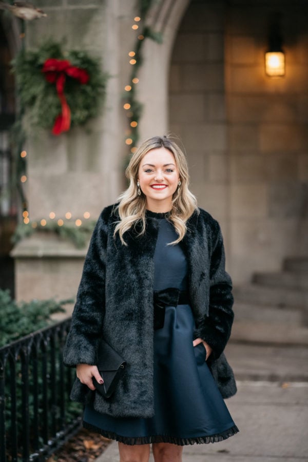 Chicago fashion blogger Jessica Sturdy wearing a faux fur coat, navy Kate Spade dress, and Loren Hope earrings.