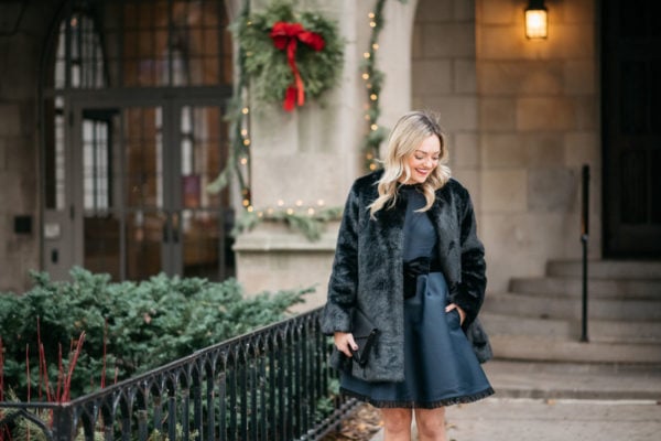 Chicago fashion blogger Jessica Sturdy wearing a faux fur coat, navy Kate Spade dress, and Loren Hope earrings.