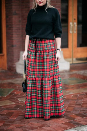 Jessica Sturdy styling a black sweater with a J.Crew tiered tartan plaid maxi skirt for a holiday party.