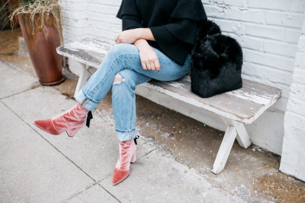 Jessica Sturdy of Bows & Sequins at Maison Marcel in Chicago. She's wearing a black ruffle sleeve sweater, Levi's 501 boyfriend jeans, and pink velvet booties with a black fur bag.